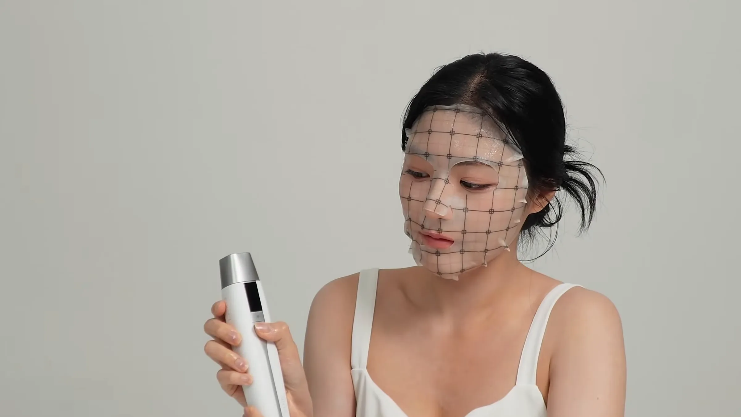 Modelo con Grid Mask puesta sosteniendo el TECH FIT