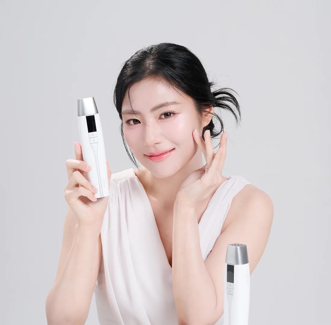 Modelo sonriente con el TECH FIT junto al rostro, fondo gris